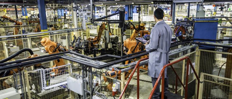 industrial automation technician monitoring robots